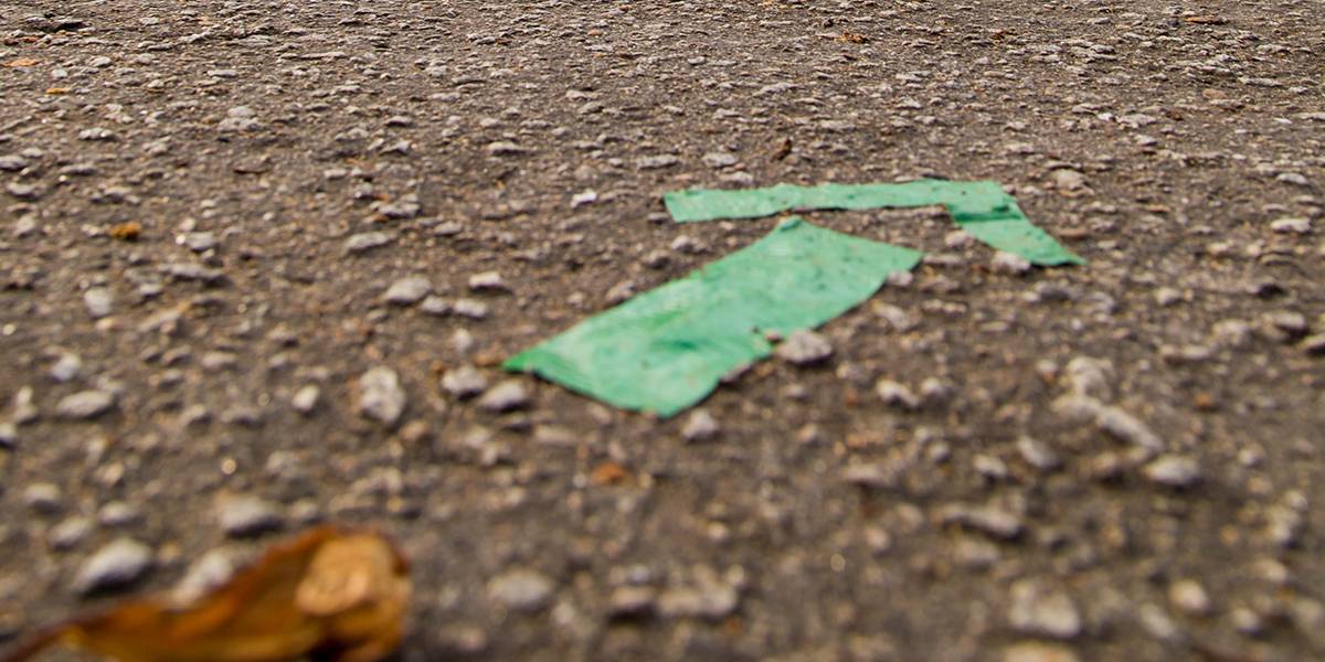Fita verde colada no chão da rua forma seta que indica o sentido do rodízio de posições durante partida de vôlei. 